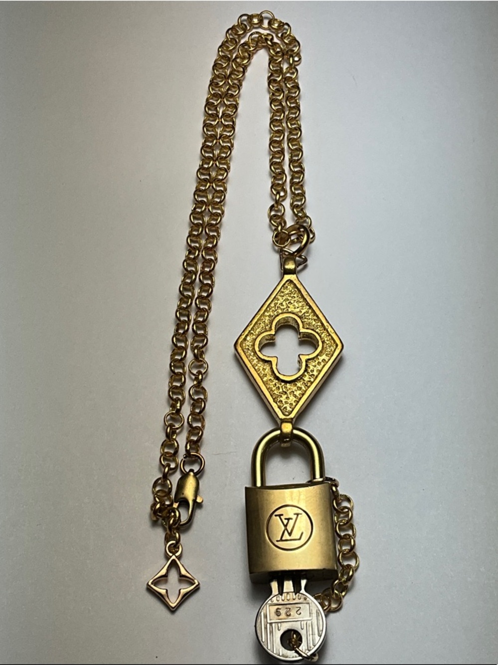 Authentic Louis Vuitton Vintage Brass Padlock Key Quatrefoil Motif on a chain